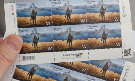 A man holds postal stamps showing Ukrainian service member and Russian warship depicting recently damaged guided missile cruiser the Moskva at the headquarters of Ukrainian post in Kyiv, Ukraine, 14 April 2022.