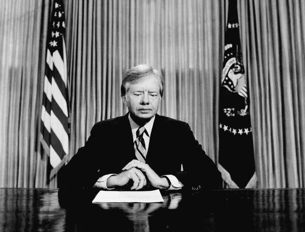 Mr. Carter sitting at a desk in the Oval Office, looking down. 