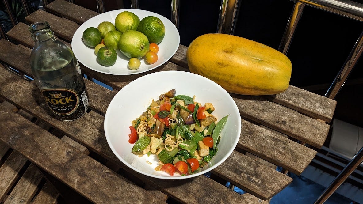 a dark table with soda water, limes and pad mama bowl