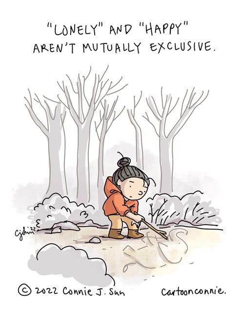 Lonely and Happy Single-panel comic illustration of a cartoon girl with a bun in the woods. The scene is quiet and calm and the girl is drawing an elephant on the ground with a branch. Caption reads, "'Lonely' and 'happy' aren't mutually exclusive." Drawing by Connie Sun, cartoonconnie, 2022.