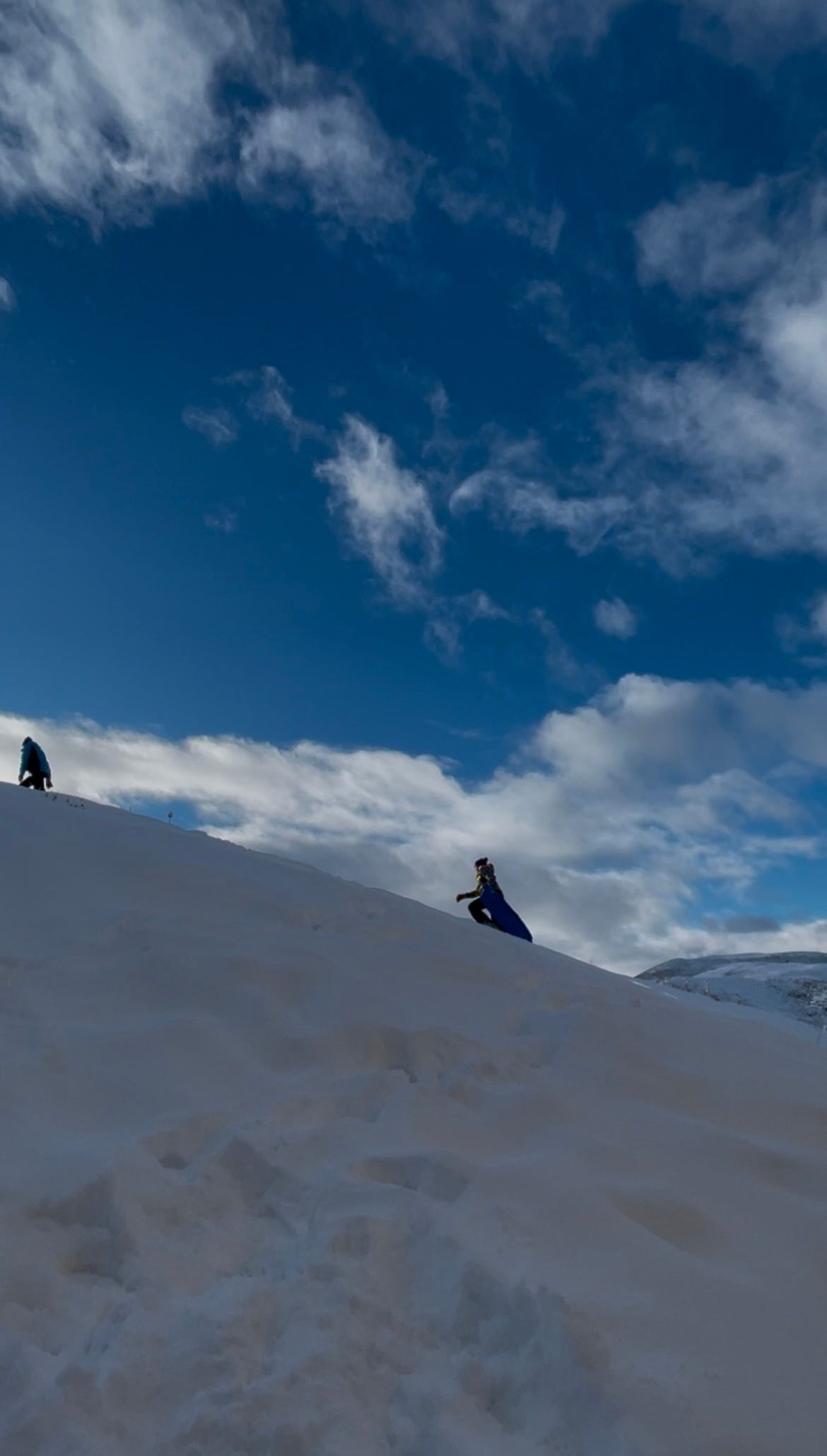 People walking up a hill in snow