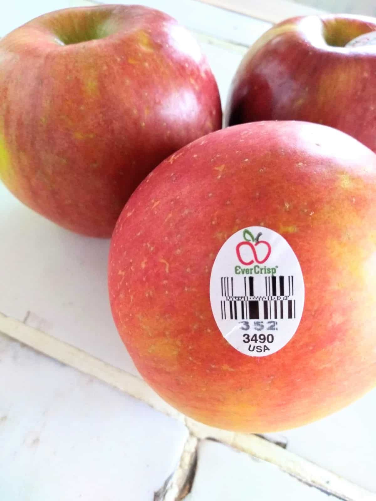 3 Evercrisp apples on a white tile counter.