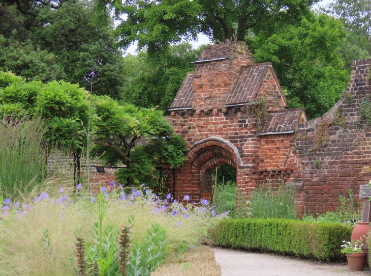 A brick arch at one end of a walled garden