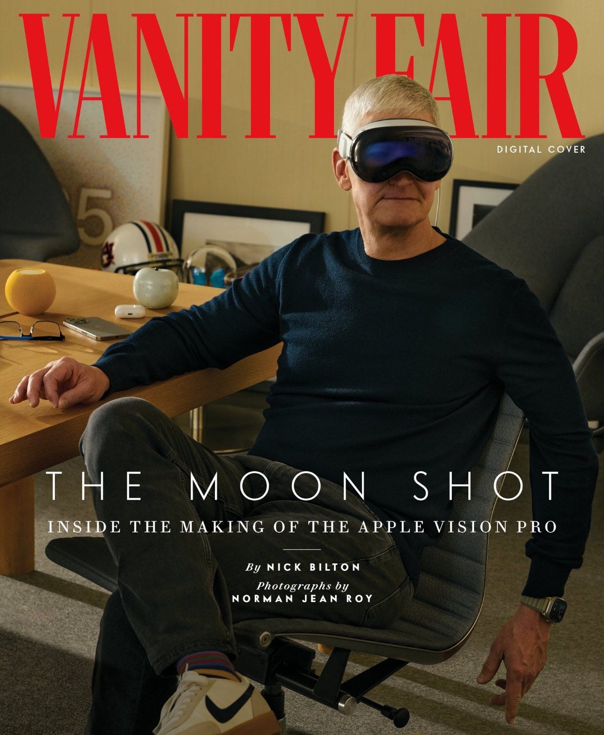 capa da revista Vanity Fair, que traz uma imagem de Tim Cook sentado na sua cadeira de escritório, com roupas casuais, encostado na mesa usando um óculos Vision Pro, olhando para frente. a manchete diz "The Moon Show - inside the making of the apple vision pro"