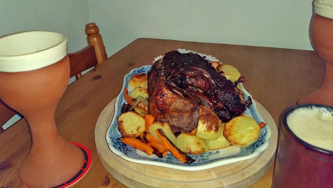 A hearty meal on a wooden platter, laid out on a wooden table.