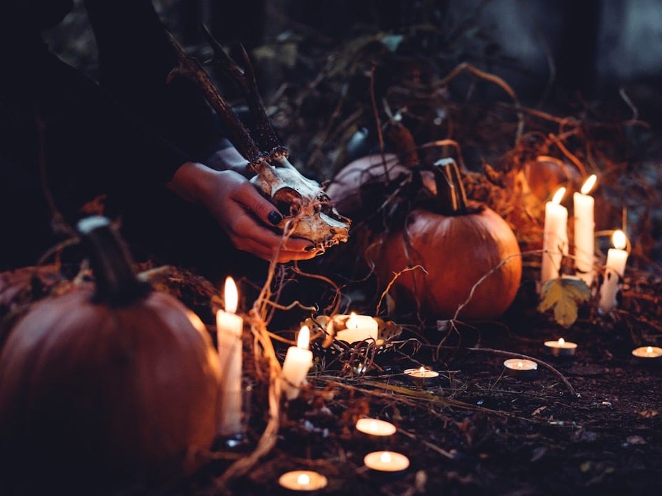 person decorating pumpkin and candles