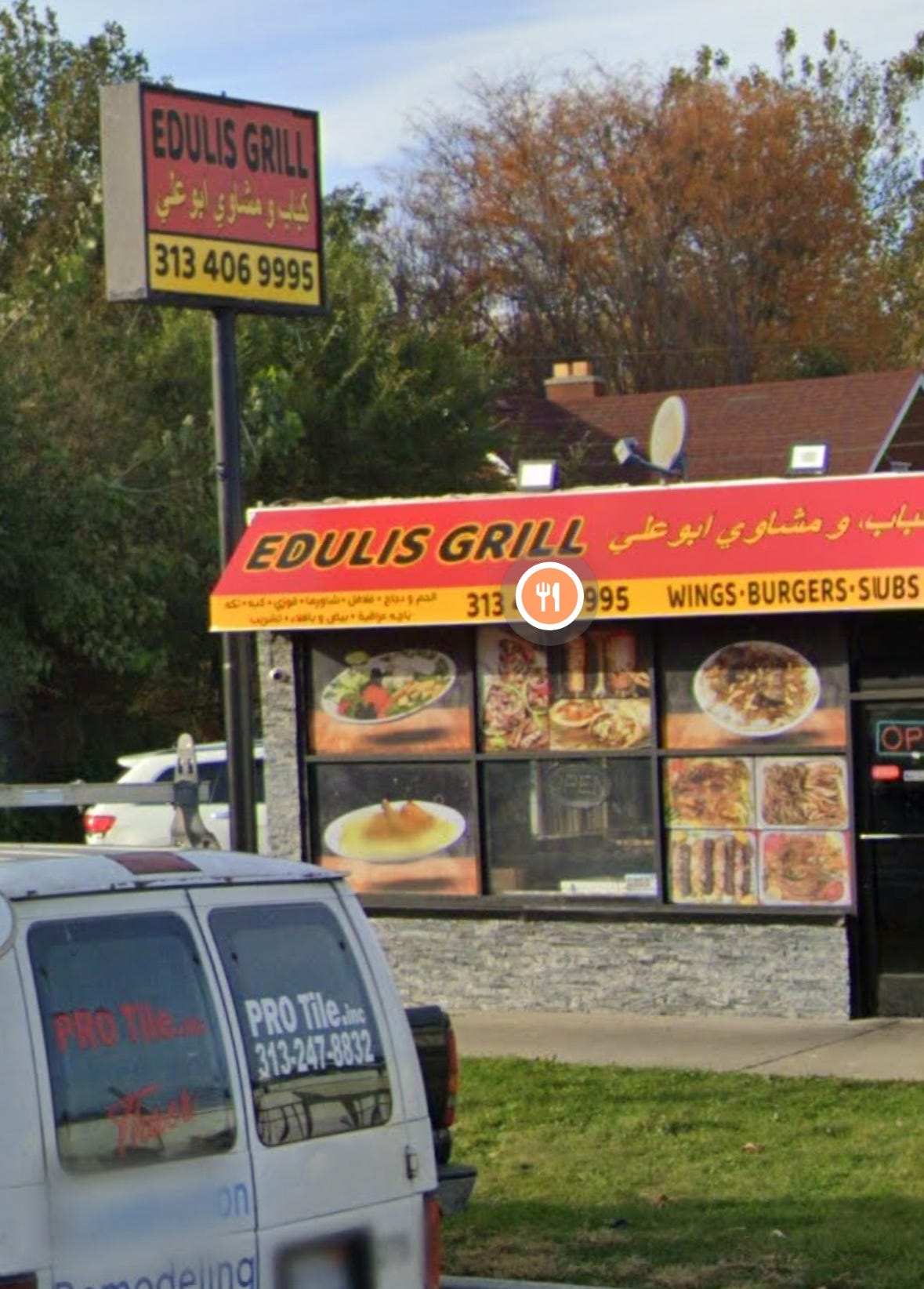 A photograph of a restaurant in Dearborn called "Edulis Grill" its awning is partially written in Arabic but in English it says "Wings Burgers Subs"