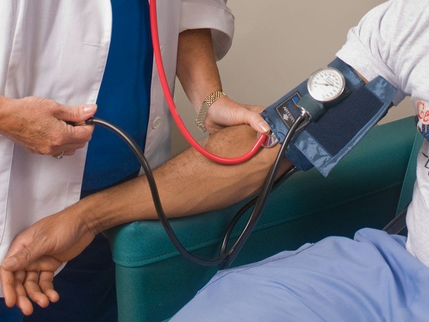 a doctor checking a patient's blood pressure with a stethoscope a doctor checking a patient's blood pressure with a stethoscope