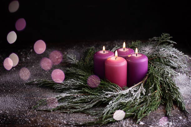 Stock image of Advent candles adorned with some greenery