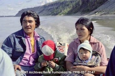 Ernie and Wilma Manuel on a motorboat outside Fort Good Hope with their children in July 1984. NWT Archives/Rene Fumoleau fonds/N-1998-051: 3147