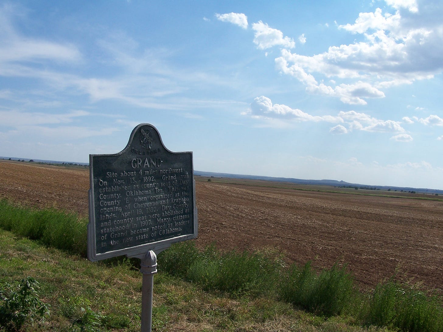 Site about 4 miles northwest. On Nov. 13 1892, Grand was established as county seat of Day County, Oklahoma Ter. This was County 'E' when organizers at the opening of Cheyenne and Arapaho lands April 19, 1892 Day County and county seat were abolished at statehood in 1907.  Many citizens of Grand became noted as leaders in the new state of Oklahoma.    (Antelope Hills in Background)
