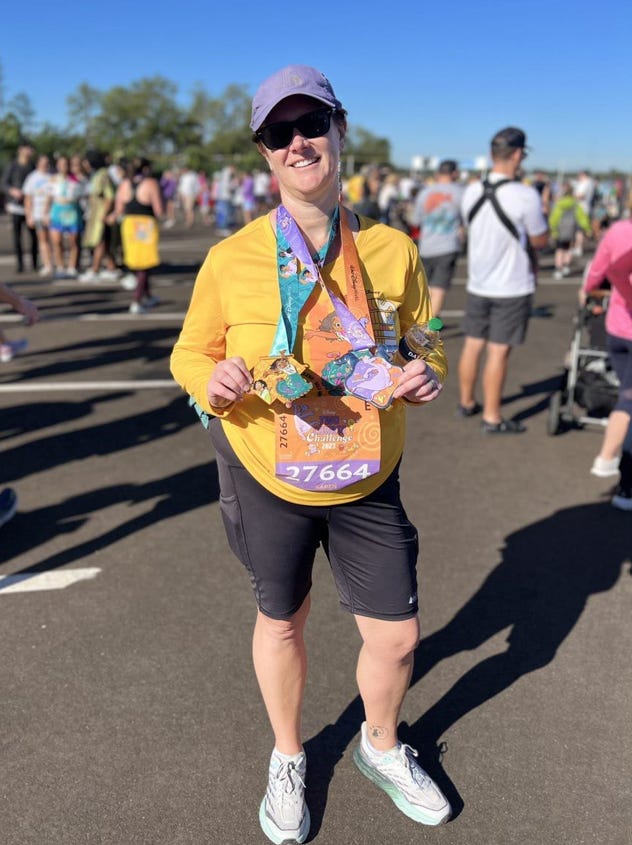 The author at the end of the marathon, holding her medals.