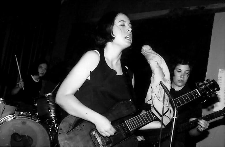 A black and white photo of an all-female band performing on stage.