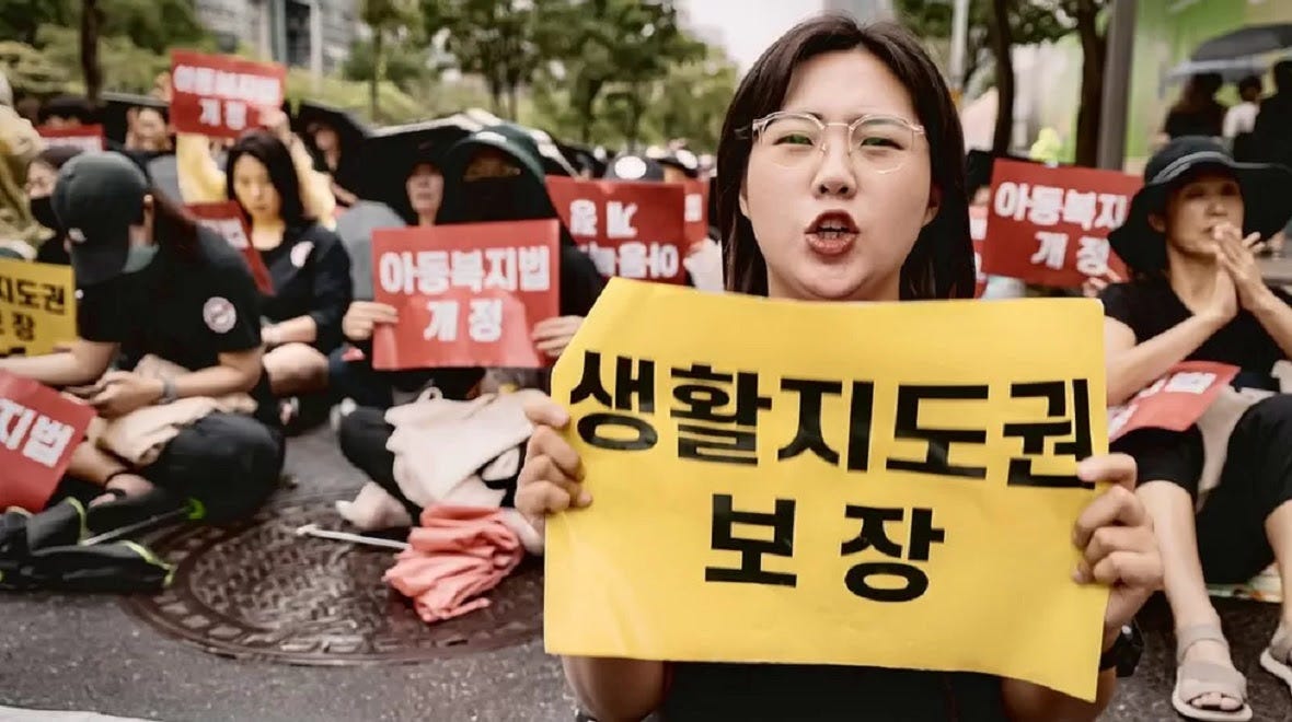 Teacher Kim Jin-seo holds up a placard at a recent protest 