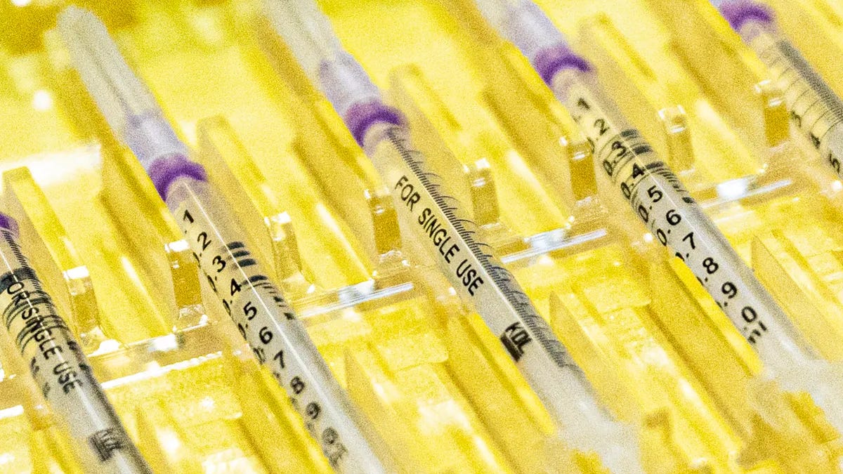 Prepared syringes are lined up in a yellow tray.