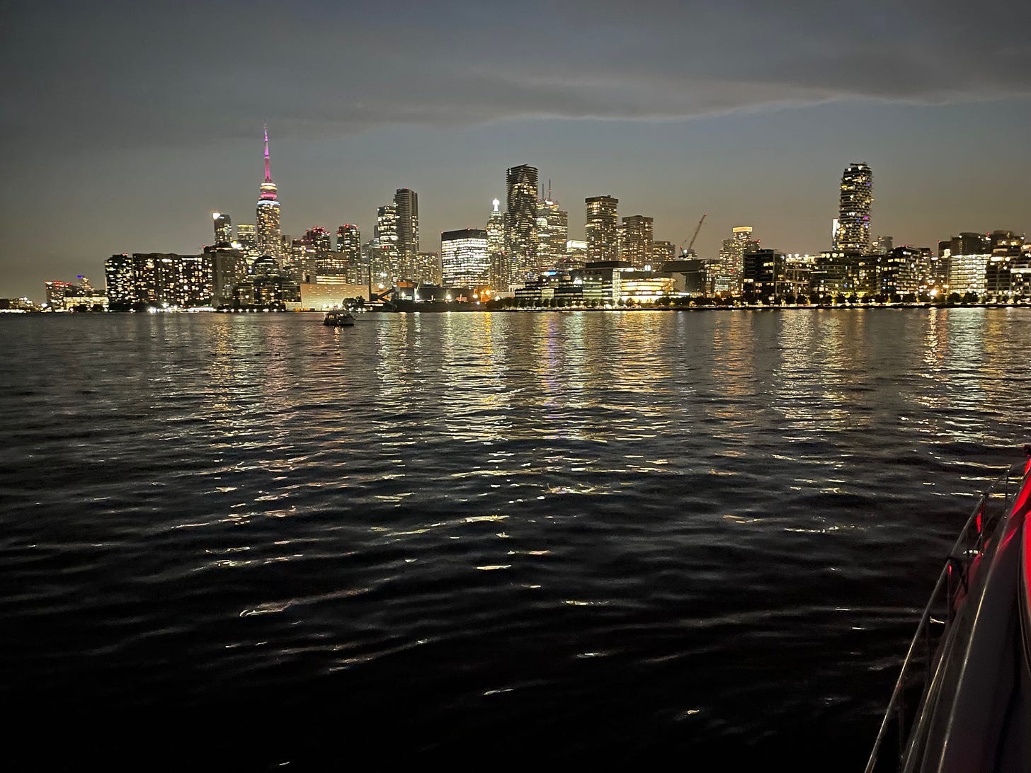 A photo of the Toronto city skyline, taken from the water at dusk