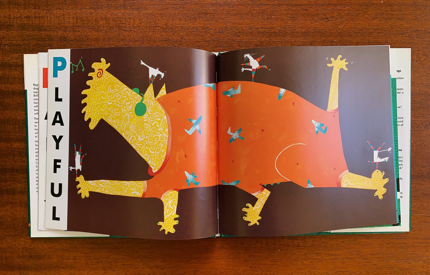 A spread of a made up animal in yellow with the word "PLAYFUL" from the book "C is for Curious"