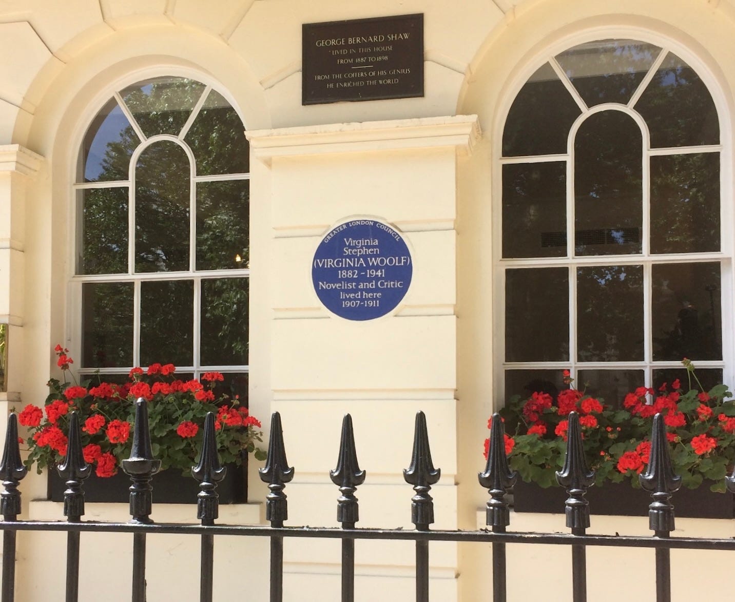 A house facade in a London square with two arched windows and a blue plaque for Virginia Woolf and anther plaque for George Bernard Shaw.