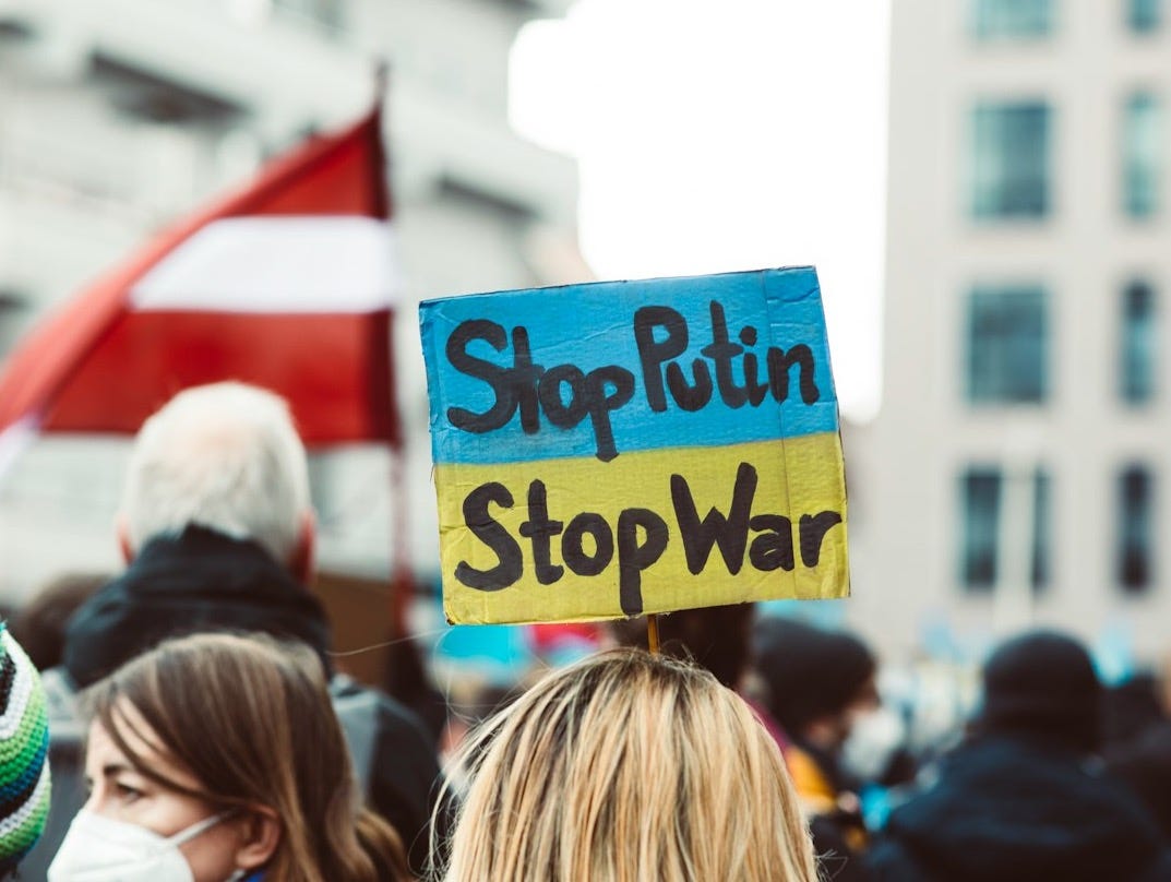 a group of people standing around each other holding signs a group of people standing around each other holding signs