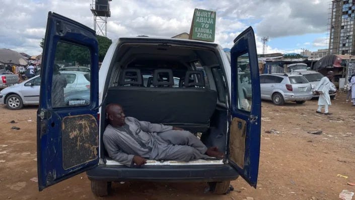 Jume Hanwa takes a nap at the trunk of his empty vehicle at Utako Motor Park, an interstate bus terminal in the Nigerian capital of Abuja. - Nimi Princewill/CNN