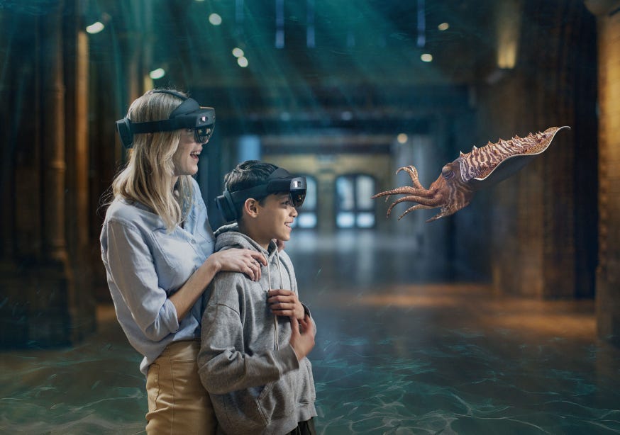 A woman and boy wearing VR headsets looking at a squid floating in mid air 