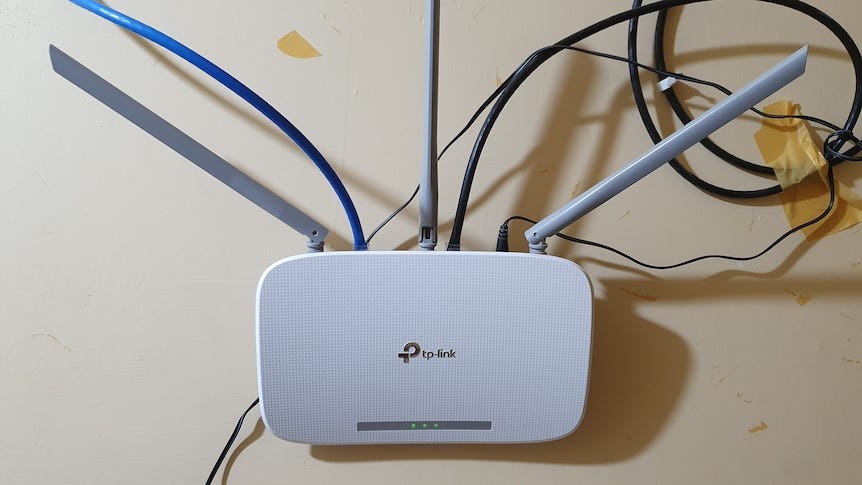 A white wall mounted TP-Link Wireless N Router.