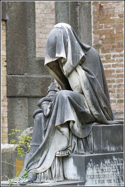 This may contain: the statue is sitting in front of an old building