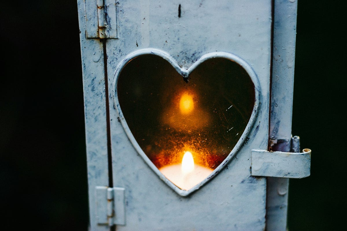 Heart design with a lit candle behind it. Heart design with a lit candle behind it.