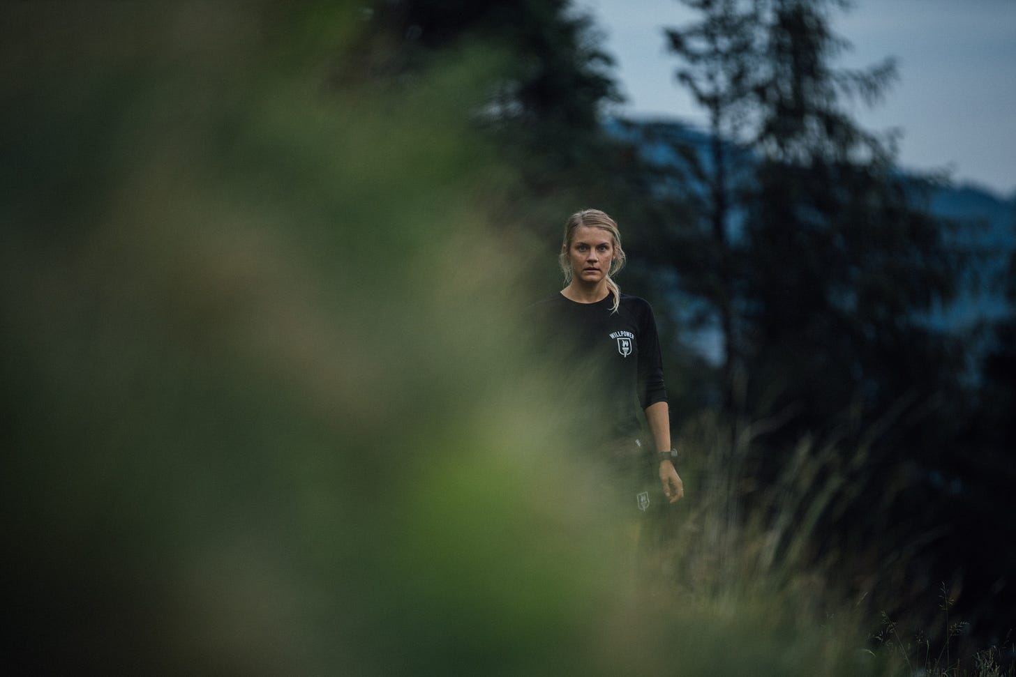 Female runner behind a grass hill