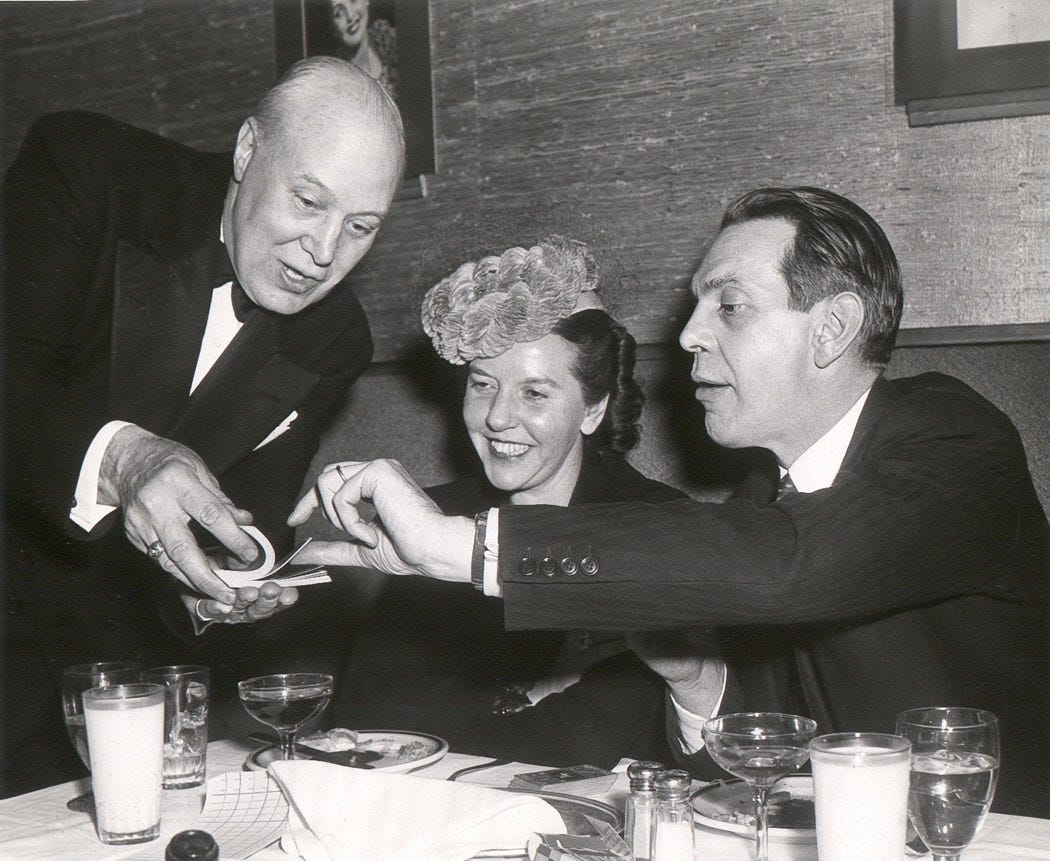 Jack Spooner playing a card trick for Raymond Massey and his wife.
