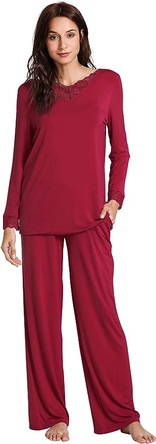 Brunette woman in wine red pajama top and pants with red lace trim at collar and cuffs