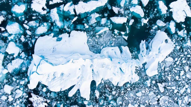 Melting Arctic Ice in Ocean Water, Blue Glacier Ice with Snow in Iceland. Climate Crisis Melting Arctic Ice in Ocean Water. Blue Glacier Ice Covered with Snow in Iceland. Climate Crisis. High quality photo north pole aerial view glacier stock pictures, royalty-free photos & images