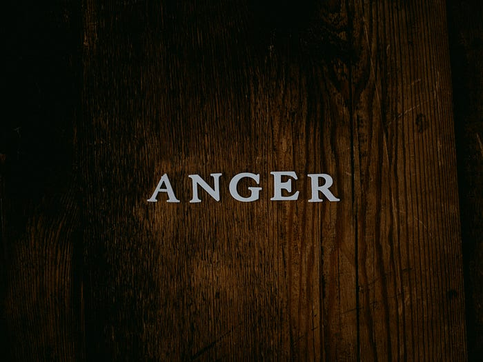 The word Anger spelled out in white letters against a dark wood background. The word Anger spelled out in white letters against a dark wood background.