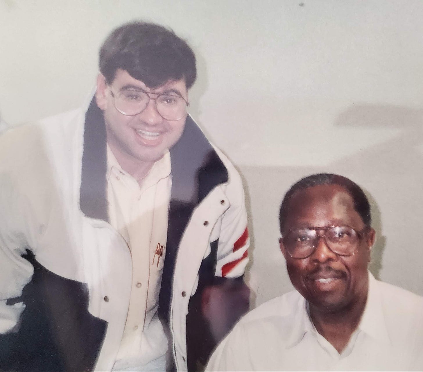 Jordan's father Hank Aaron (left) smiling for a picture with baseball great Hank Aaron seated beside him (right)