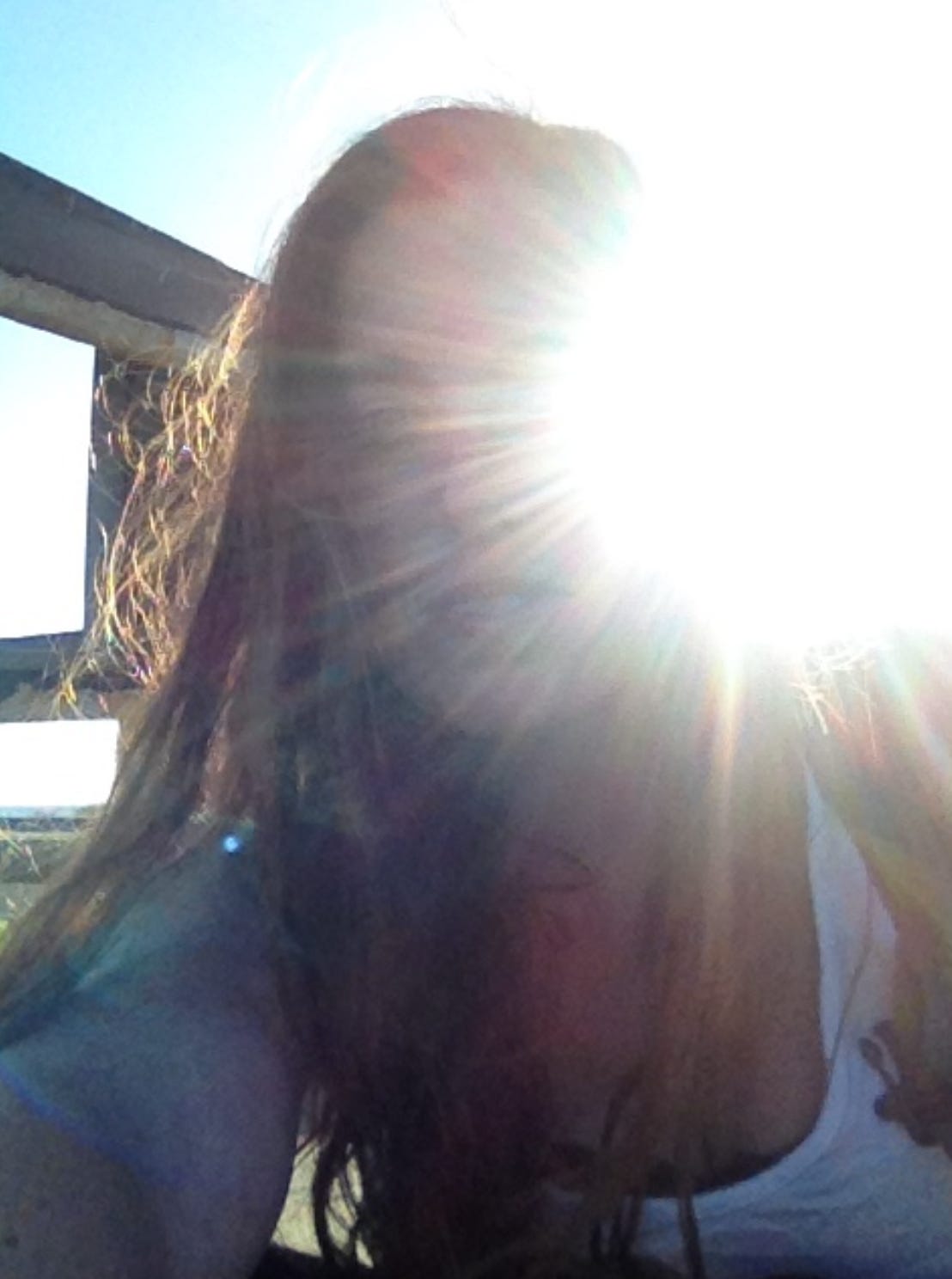A woman's face obscured by backlit sunlight, a determined "finding myself" expression