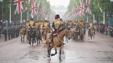 PA Media Horses ride down the Mall in heavy rain