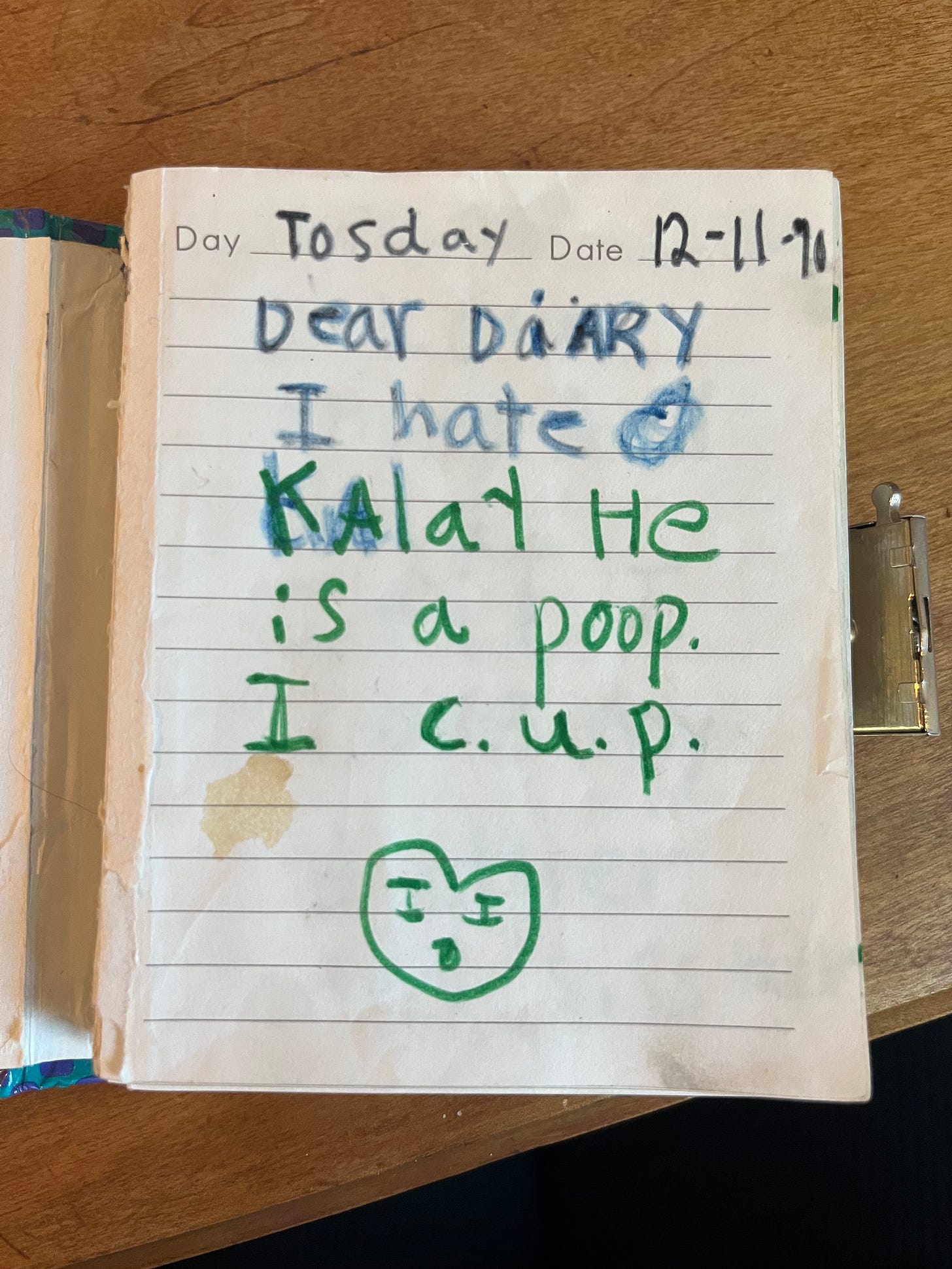 Interior page of Amber's childhood diary. Text reads: "Tosday 12-11-90 Dear Diary, I hate Kalay He is a poop. I c.u.p."