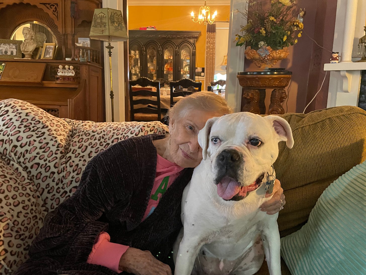 A woman and a white dog on a couch.