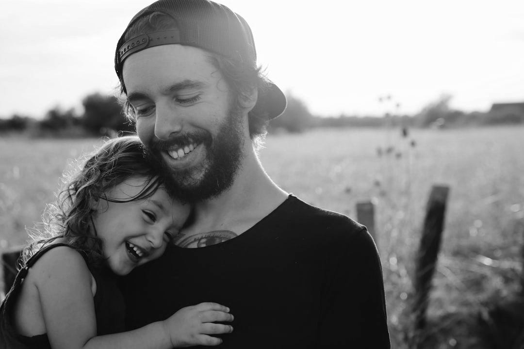 man carrying daughter in black sleeveless top