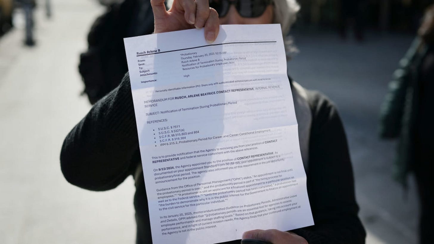 Arlene Rusch, former Internal Revenue Service worker, shows an email notifying her that she has been laid off, as she leaves her office in downtown Denver, Colorado, Feb. 20, 2025. The IRS began laying off roughly 6,000 employees in the middle of tax season as the Trump administration slashes the federal workforce.