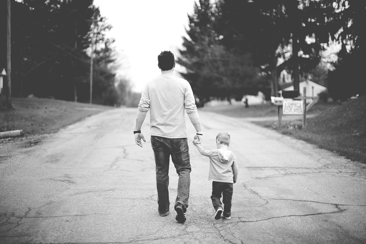 Father and son walking down a street