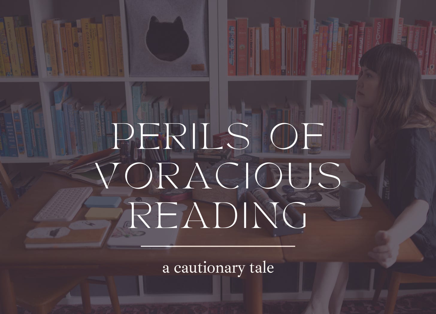 Caroline, a white woman with dark brown hair, sits staring into space at a wooden table covered in books and notecards. In the background there is a bookcase sorted by color, packed with books. Text: Perils of voracious reading: a cautionary tale