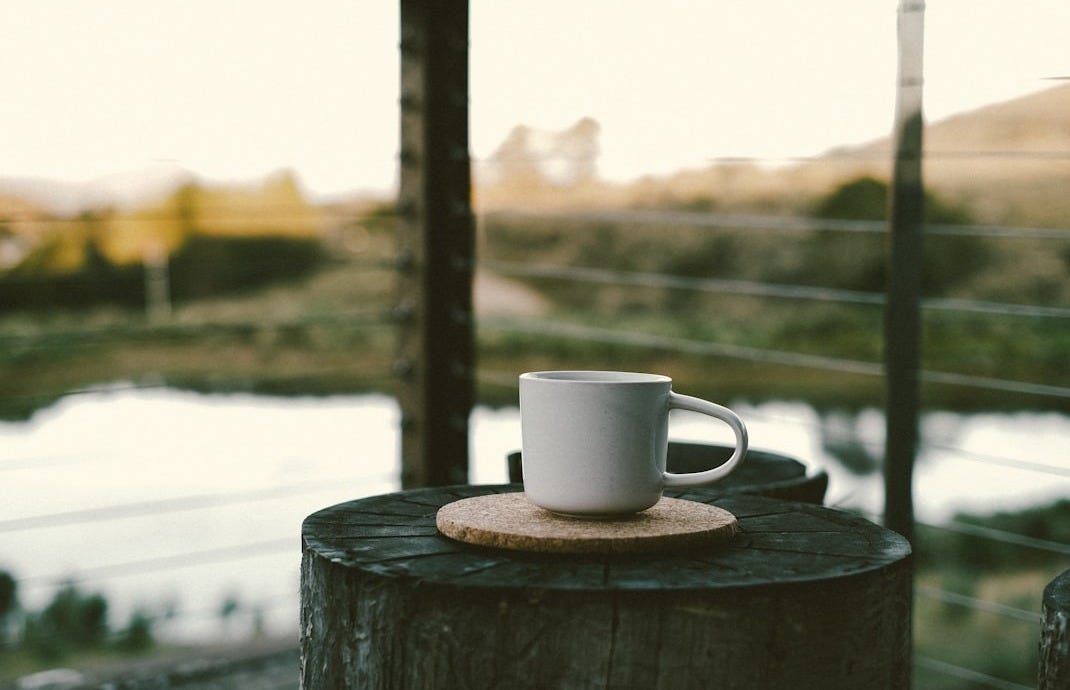 a cup of coffee sitting on top of a wooden table a cup of coffee sitting on top of a wooden table