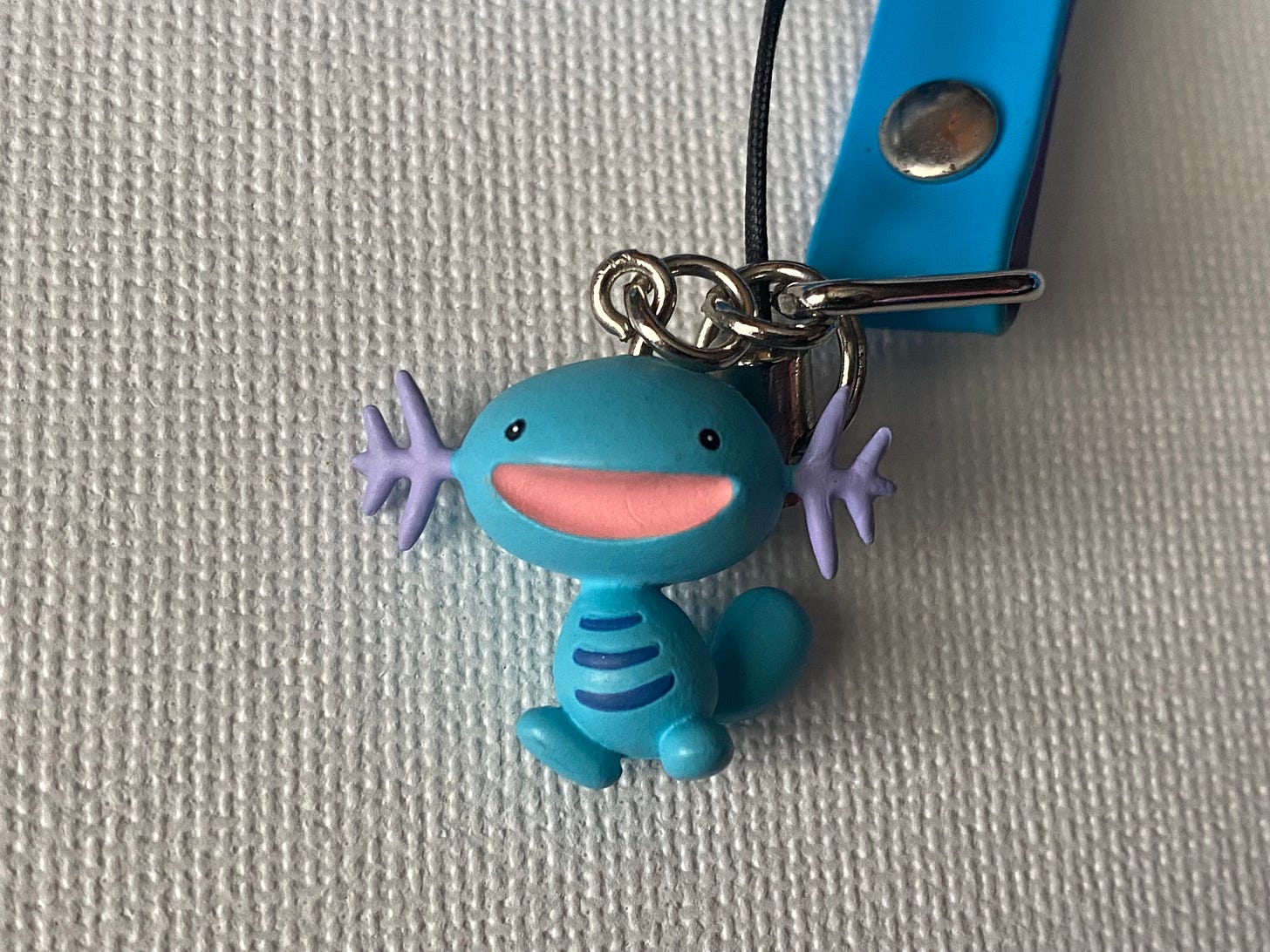 A close up of Tatton’s Wooper key charm