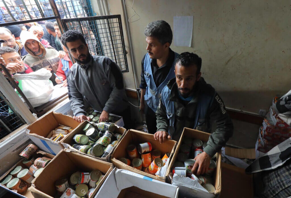 Des foules de Palestiniens attendent de recevoir des boîtes de conserve dans une école pour personnes déplacées à Deir Al-Balah, dans le centre de la bande de Gaza. (Images APA)