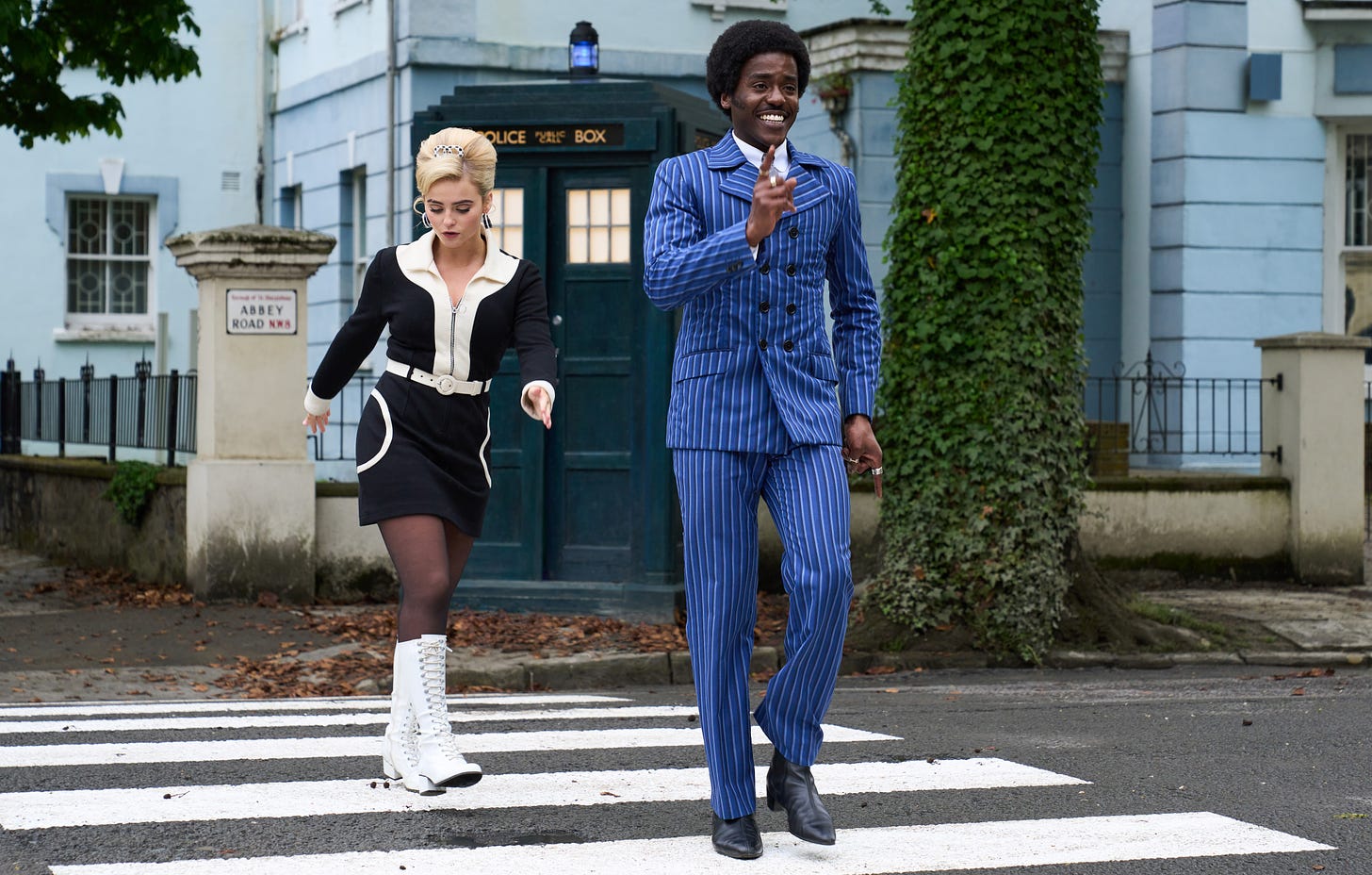 The Doctor (Ncuti Gatwa) and Ruby (Millie Gibson) crossing Abbey Road with the TARDIS behind them in a publicity photo from The Devil's Chord