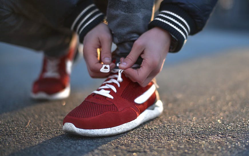 red running shoes - person tying laces