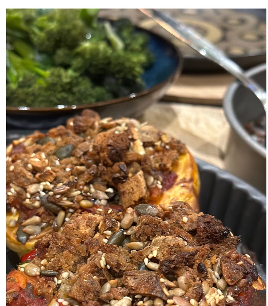 Close up of acorn squash with gluten and dairy free topping and a side of broccoli.