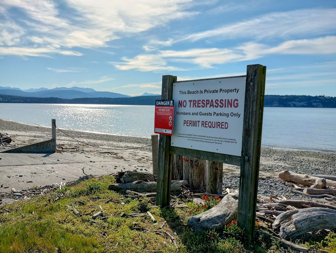 Large sign saying this is a private beach, with no trespassing sign and chain across beach entrance