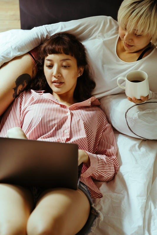 Two people relaxing looking at a laptop together